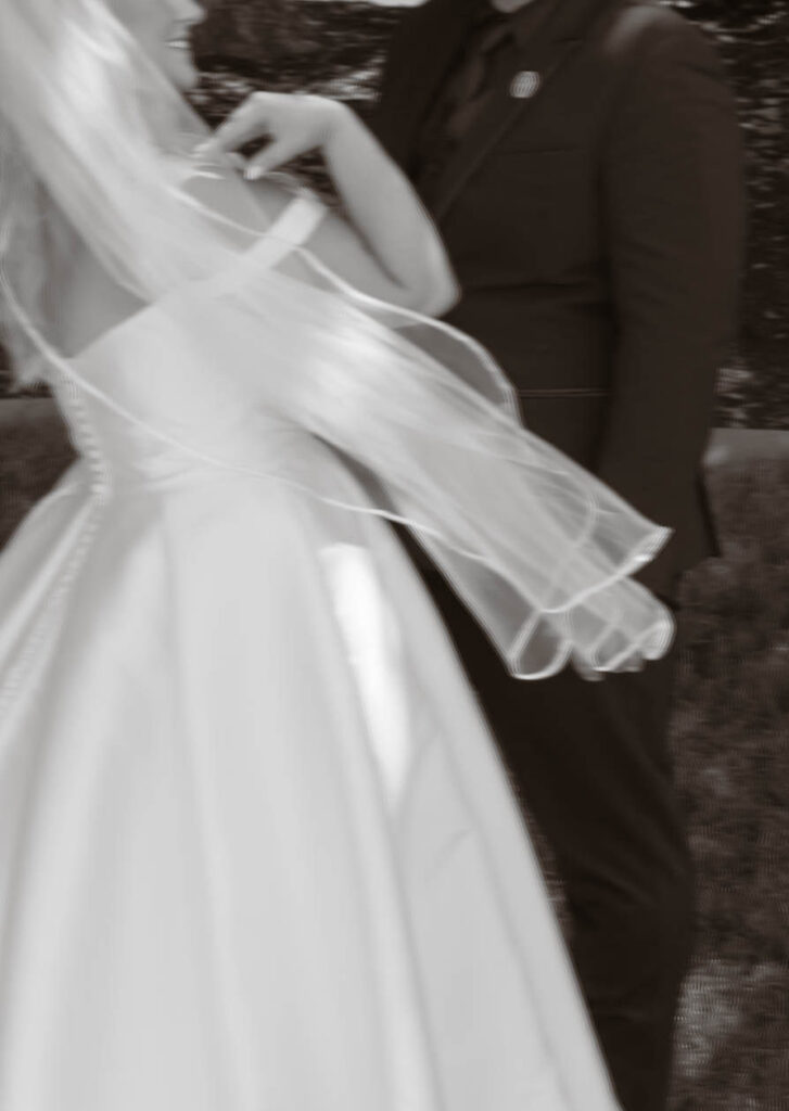 Motion-blurred photo of bride and groom walking together, the bride’s veil floating in the air at White Barn Weddings in Emmett, Idaho