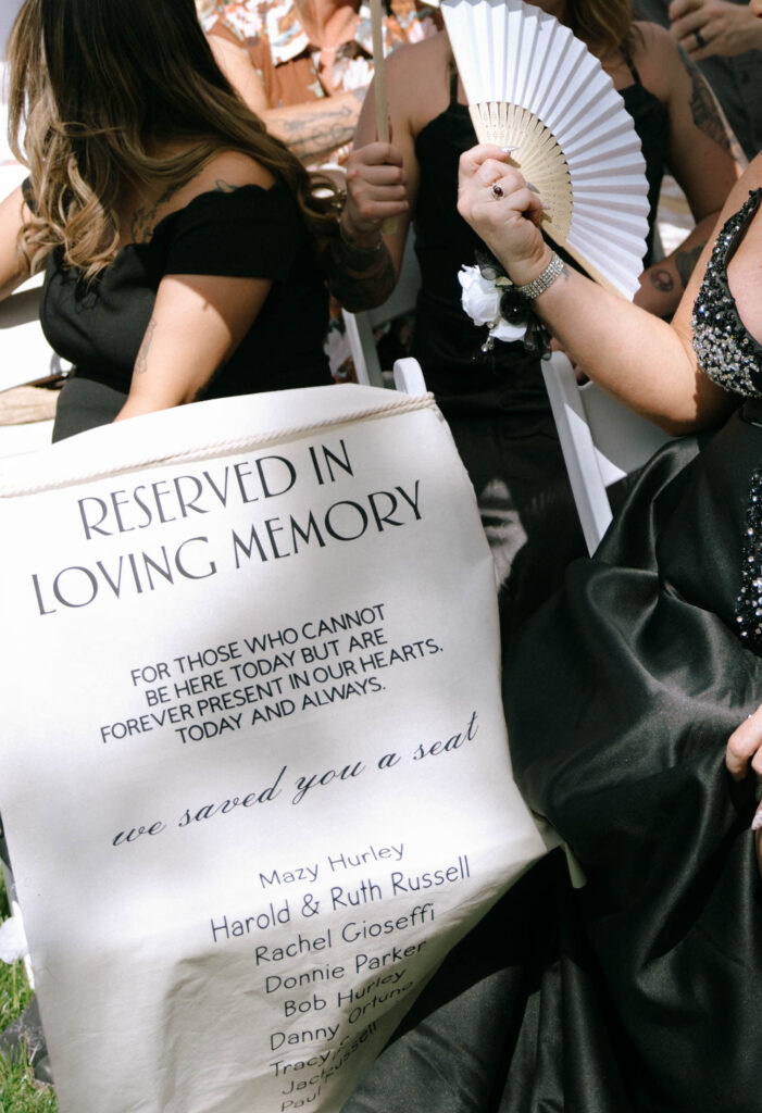 Close-up of reserved memorial seat sign honoring loved ones at McKenzie and Conner’s wedding ceremony at White Barn Weddings in Emmett Idaho